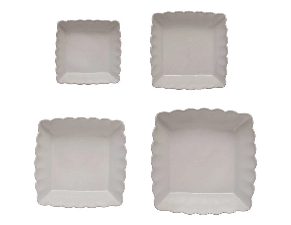 Four square paper plates with scalloped edges on a white background